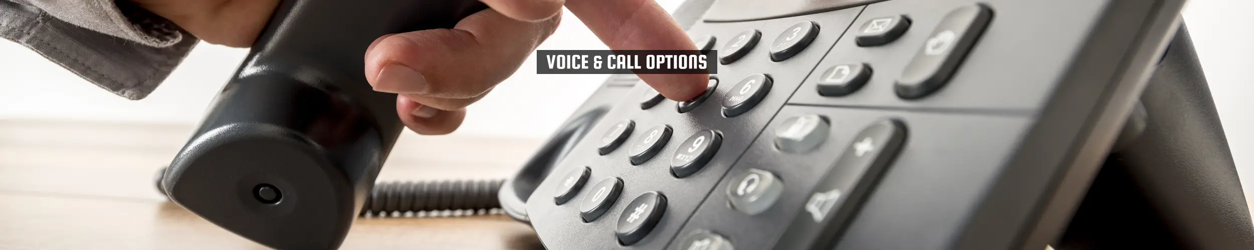 52Degrees Voice - feature image | "voice & call options" | a man keys in the numbers on a telephone | Telecoms Solutions, Norwich